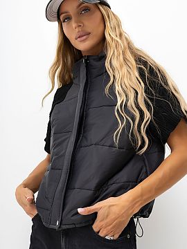 Gilet Italy Moda  A quilted women\'s vest with knitted sleeves is a stylish proposal in a casual edition, perfect for everyday, autumn, and transitional styli